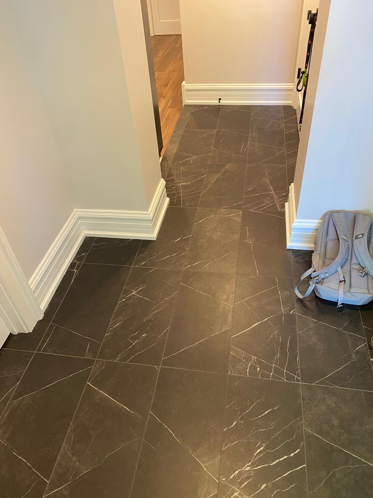 Basement hallway with natural stone flooring leading to finished living and storage areas