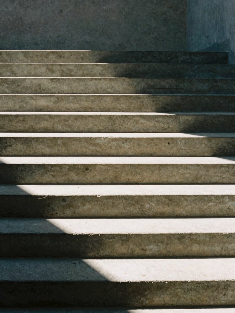 Minimalist architectural detail of concrete stairs and sharp shadows, high-contrast natural light, muted slate tones, 35mm photography