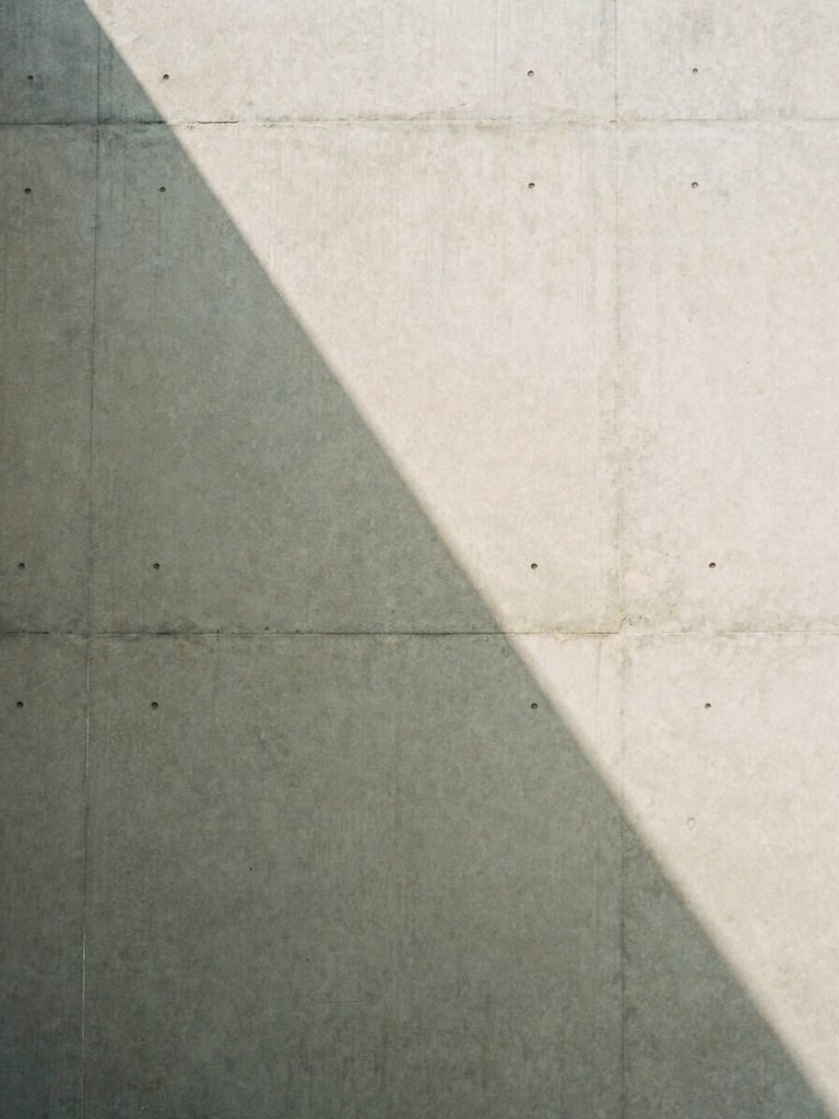 Detail of a concrete wall with a soft geometric shadow, minimalist architectural composition, natural light