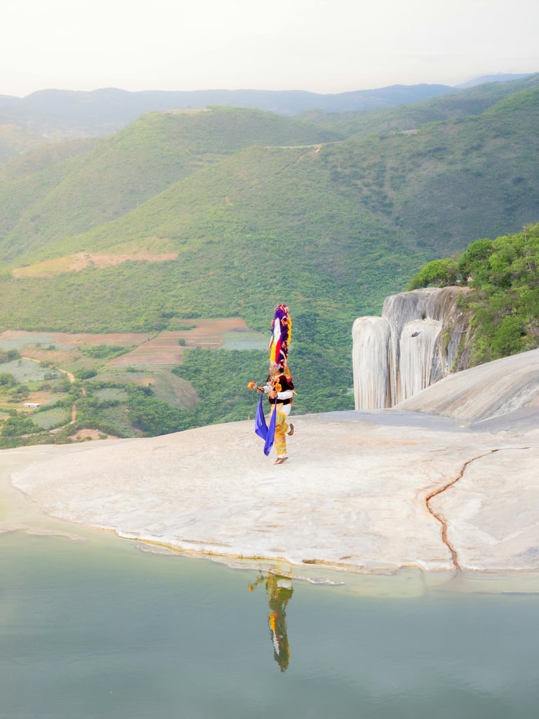 Danzante de la Pluma en Hierve el Agua, Oaxaca, frente a cascadas petrificadas