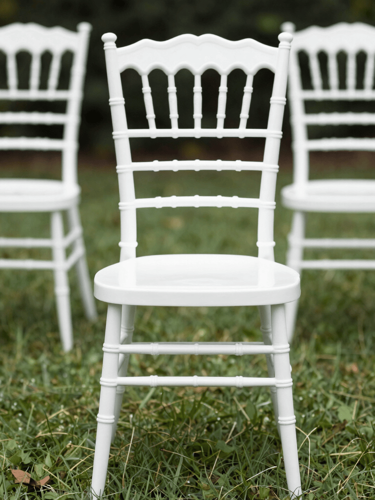 Close environmental shot looking down a row of round banquet tables inside an installed frame tent, white linen draped on each table, folding chairs set in place, natural daylight filtering through translucent sidewalls, hardware connection points visible overhead