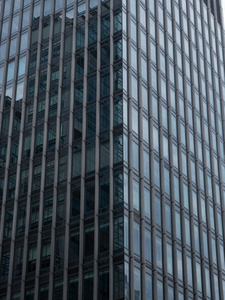 Abstract geometric pattern of glass and steel facade of a modern corporate skyscraper, cool diffused daylight, deep blue and slate gray tones, editorial corporate photography