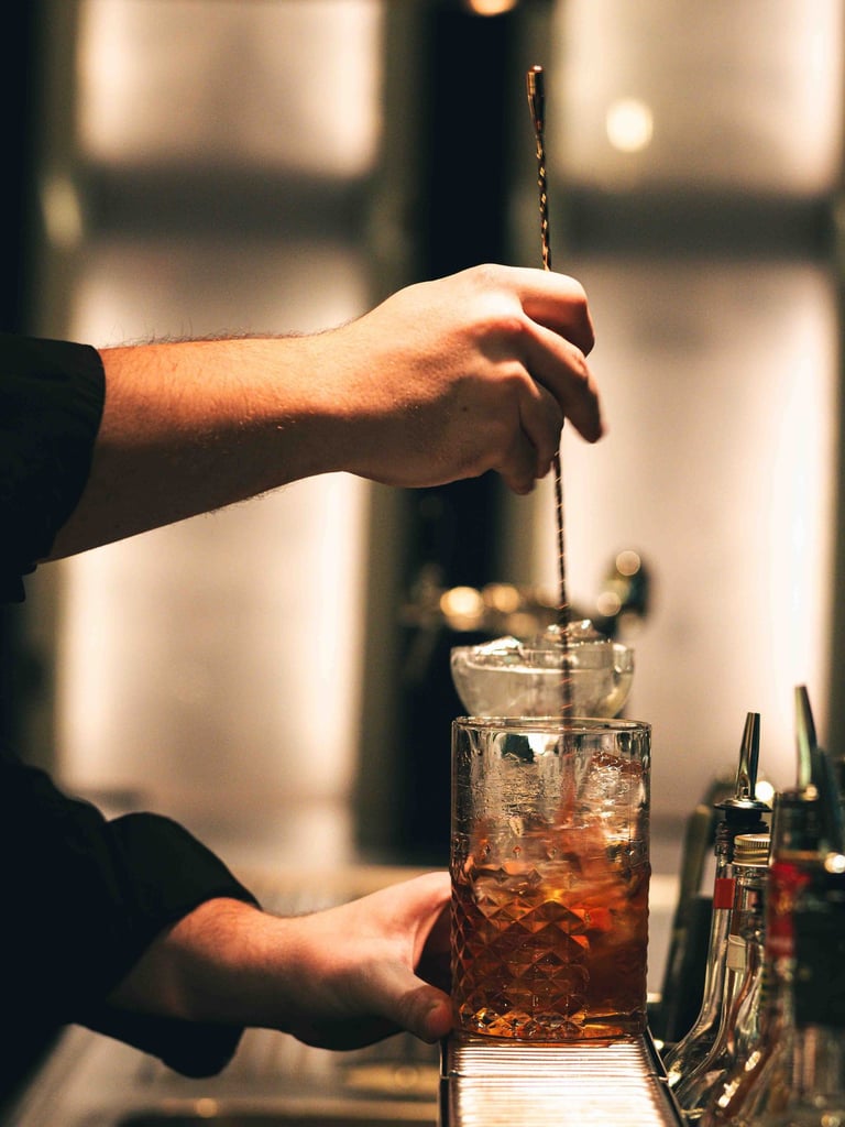 a person is stirring a cocktail