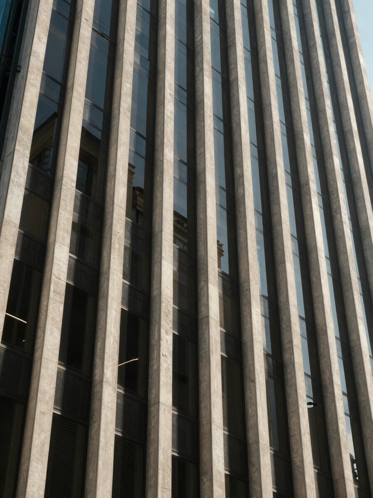 Wide environmental shot of an investment-grade commercial building facade in São Paulo, natural daylight raking across concrete and glass panels, shot from street level looking upward, strong vertical geometry, no people, no signage visible