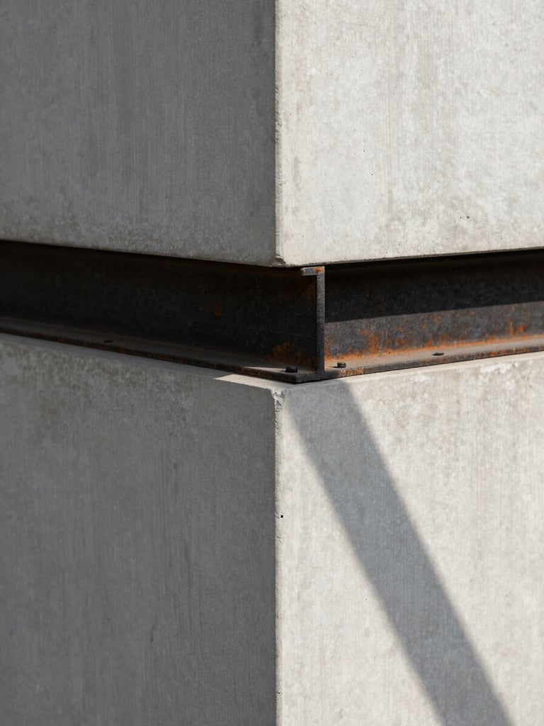 Fotografia arquitetônica em perspectiva de um ponto. Detalhe minimalista de uma quina de concreto aparente cinza claro encontrando uma viga de aço escovado escuro. Luz solar geométrica direta projetando sombras lineares nítidas. Sem pessoas.