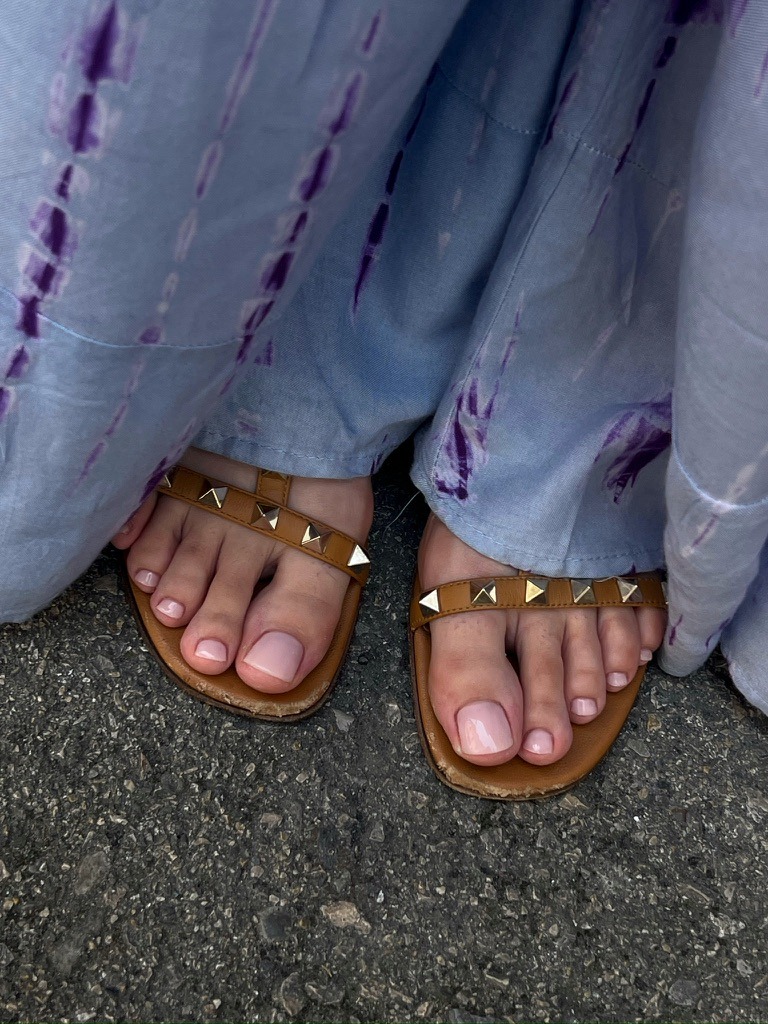 a person wearing sandals and a pair of sandals