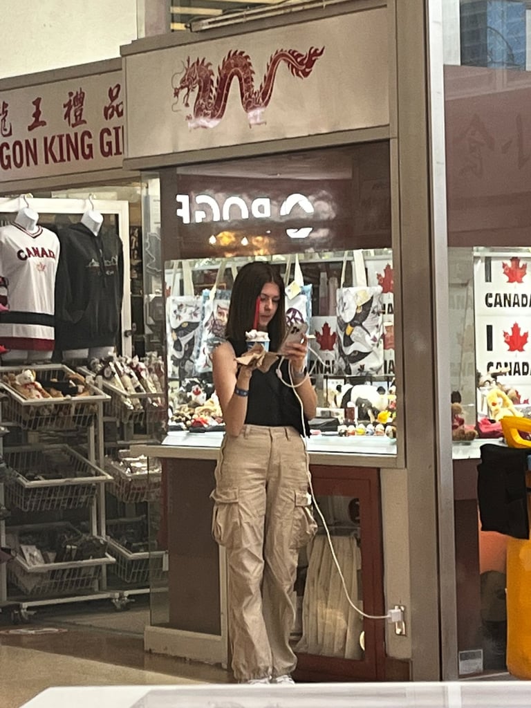 Girl looking at phone while holding ice cream