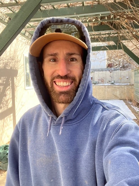 a man in a blue hoodie and a hat