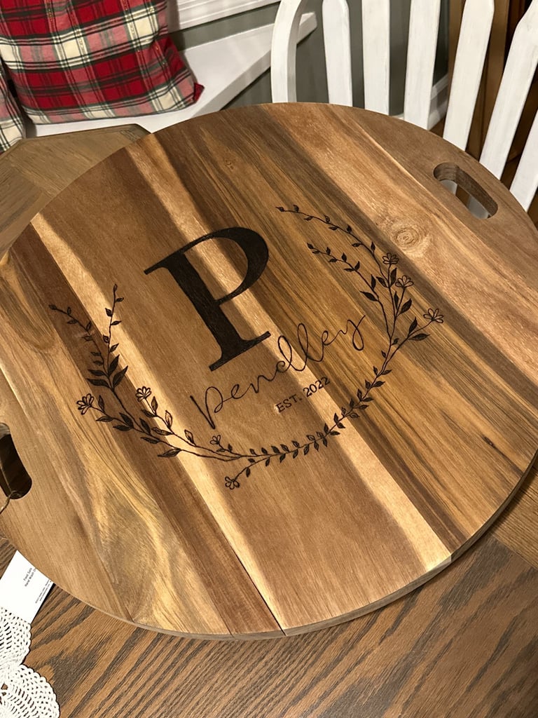 Custom engraved acacia wood serving board with personalized family name and monogram initial.