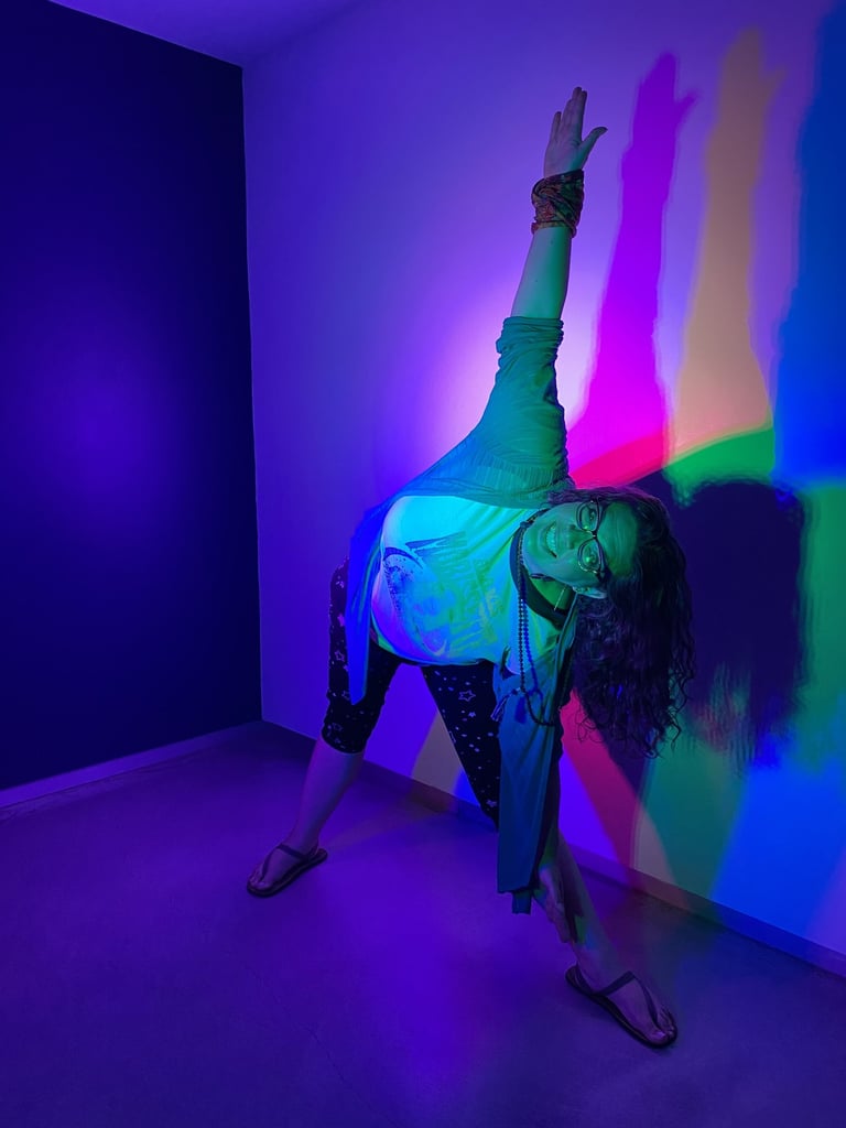 Rachel in yoga pose with neon colorful lights