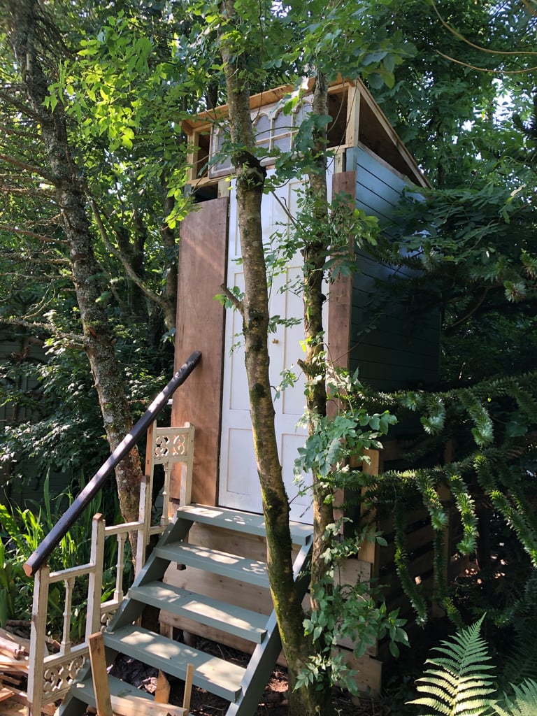 steps up to a wooden building housing a compost toilet