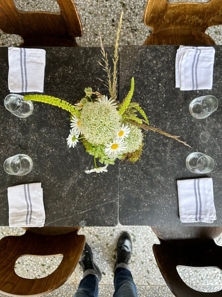 vue du dessus d'une. composition de table avec des anthemis et des album blanc 