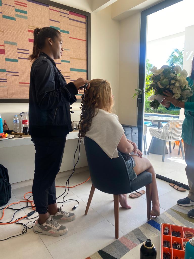 Deya Ventura bridal hair stylist curling a bride’s hair during wedding day preparations in Punta Cana, Dominican Republic