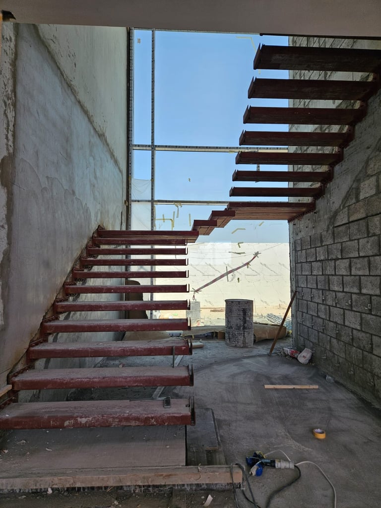 Custom steel staircase structure under fabrication on-site at UAE construction project.