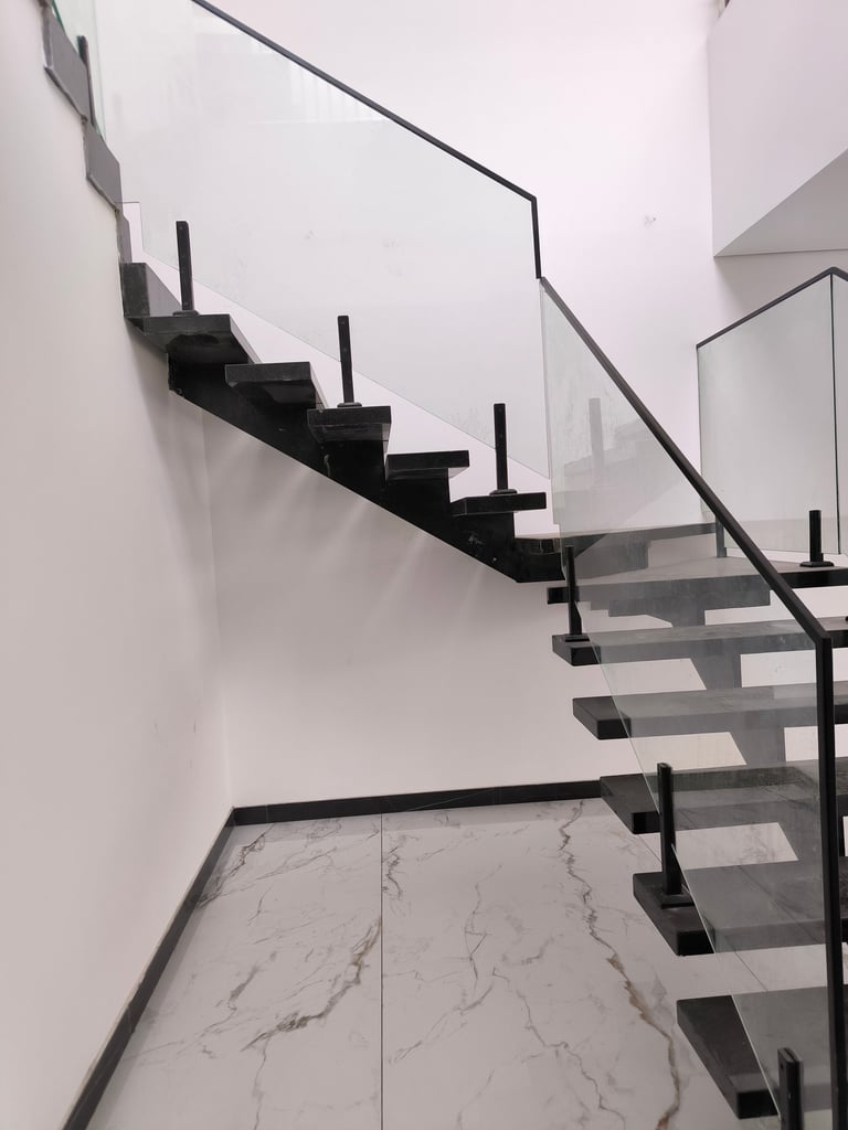 Bespoke mono-stringer steel staircase with tempered glass balustrade and slim profile.