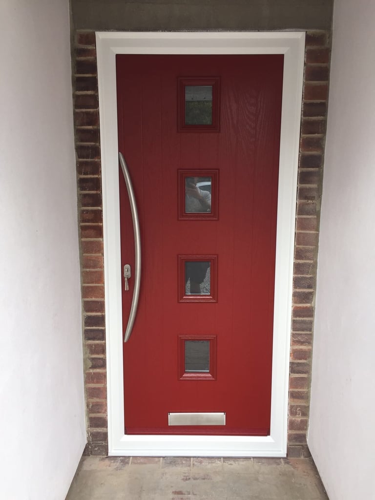 a new red composite front door with 4 squares of glass and curved long handle