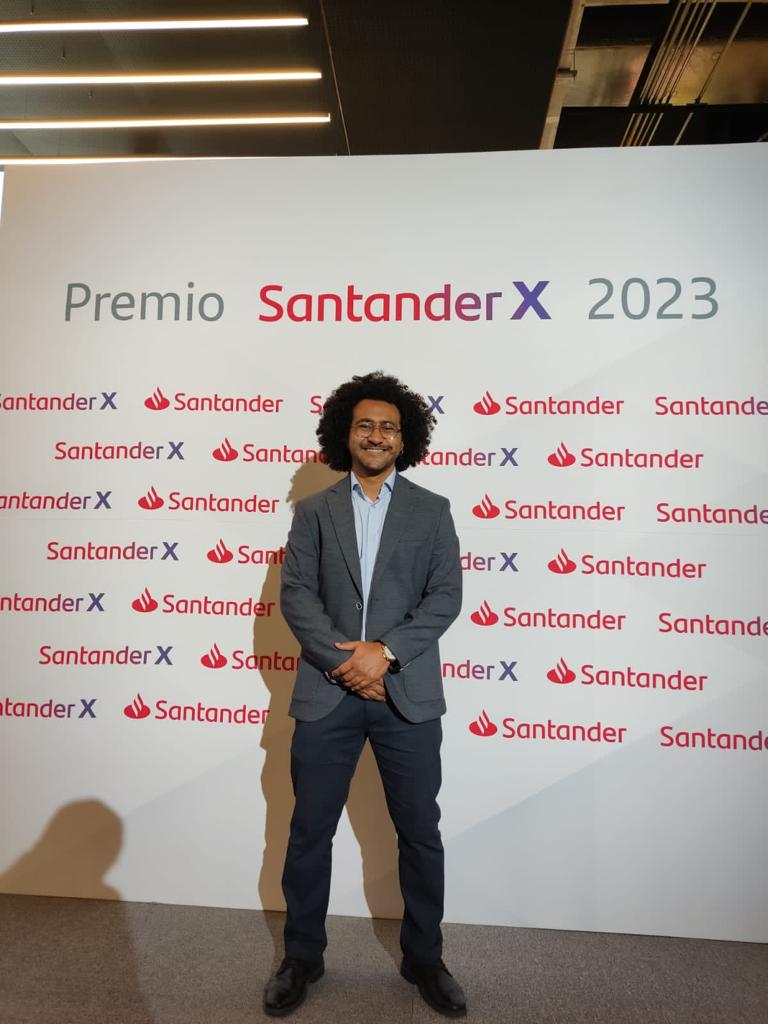 a man in a suit and tie standing in front of a sign that says,