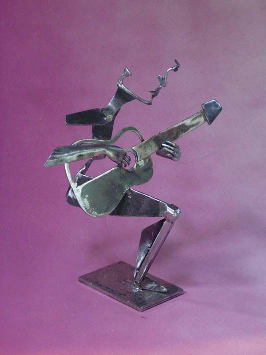 a metal sculpture of a man playing guitar