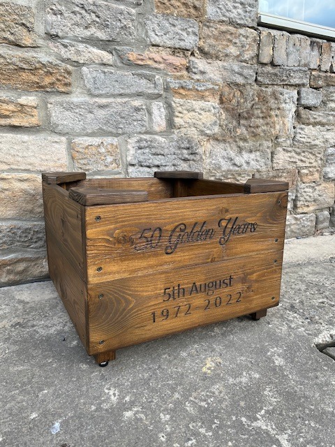 a wooden planter with personalised engraving on the front