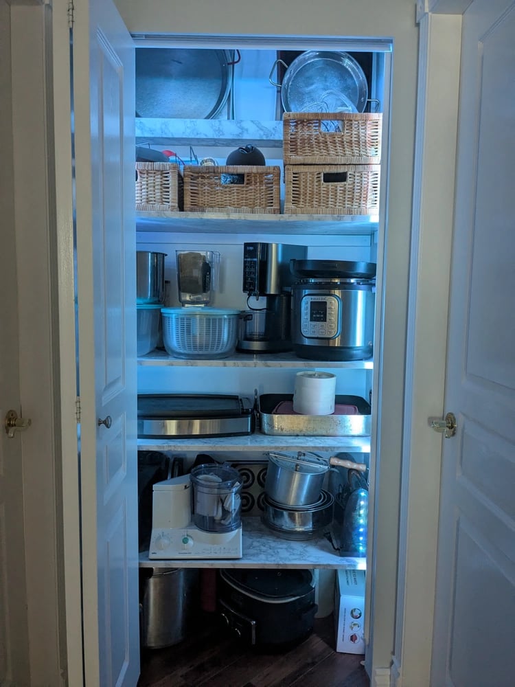 Kitchenware closet, with strip lighting to illuminate deep shelves