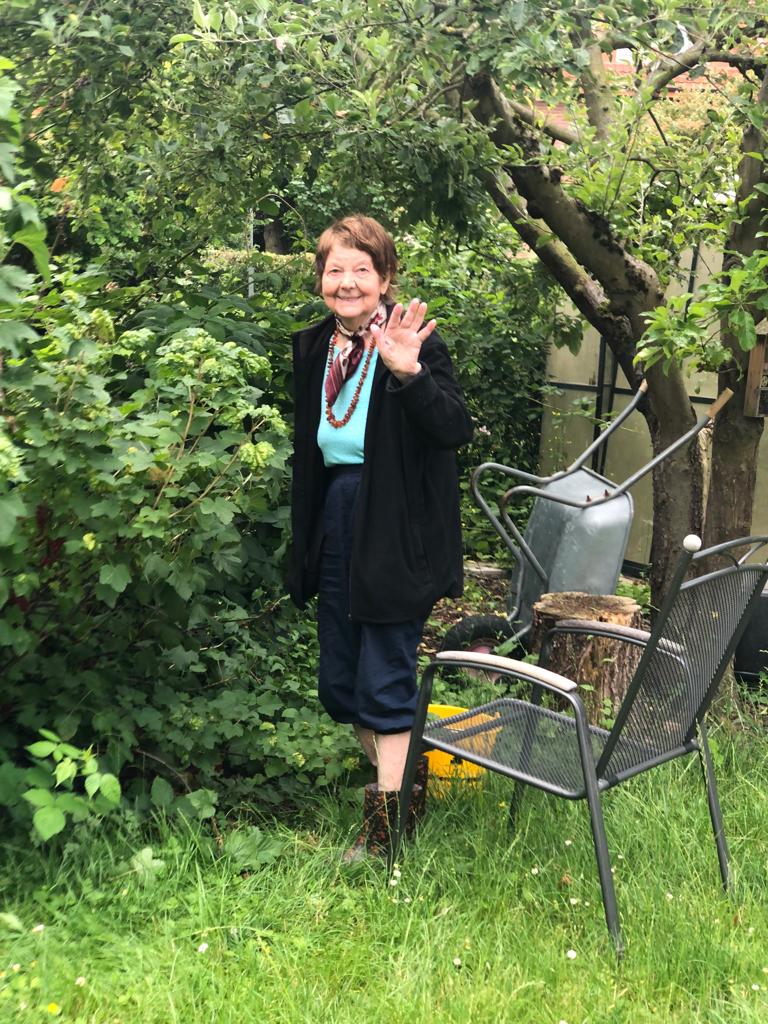 Die Mutter von Jörg im Garten. Sie winkt uns zu. Eeva Grube aus Finnland