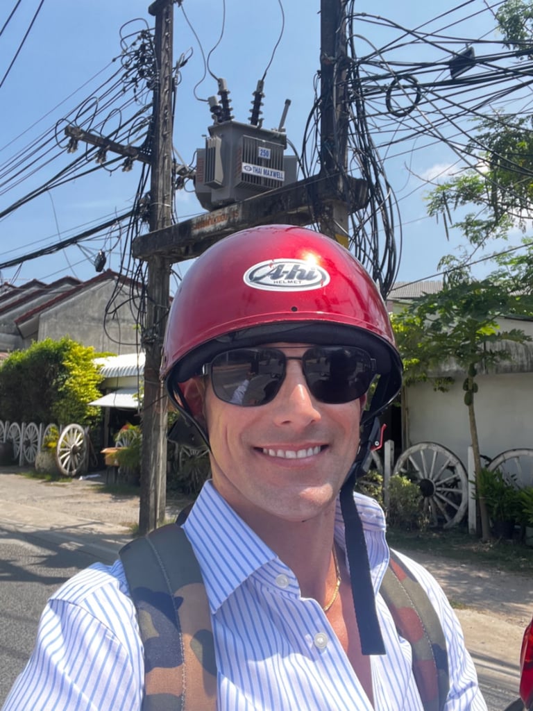 Travel writer Rick Silvia rides a scooter in Thailand