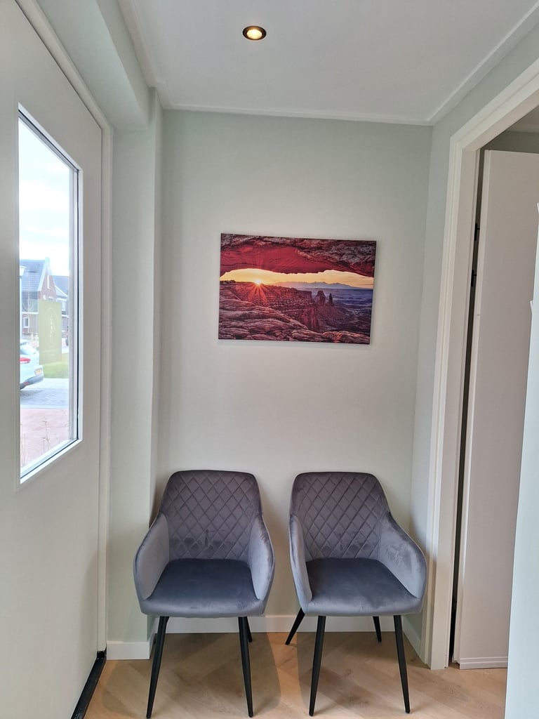 2 stoelen in een kamer met een schilderij aan de muur