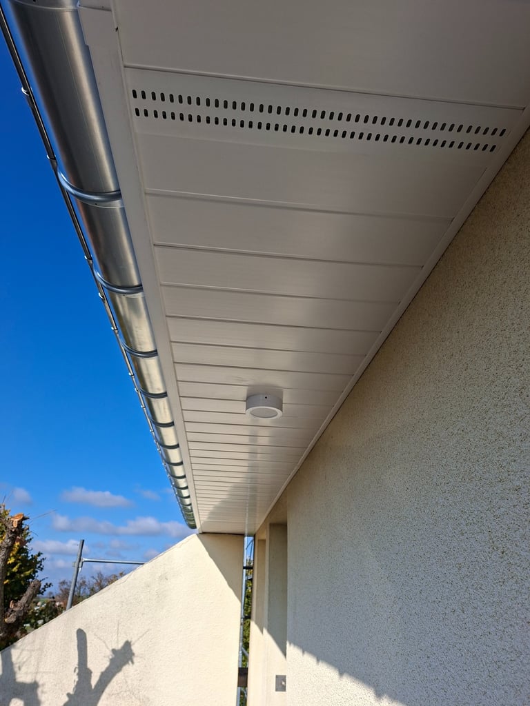 Lambris pvc blanc avec grilles de ventilation.