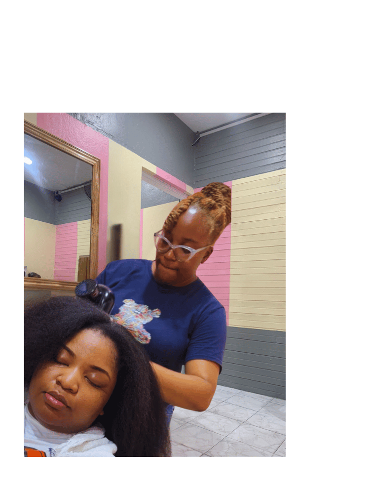 Hairstylist expertly working on a customer's natural hair at Kwik Fingaz Beauty Salon in Montego Bay.