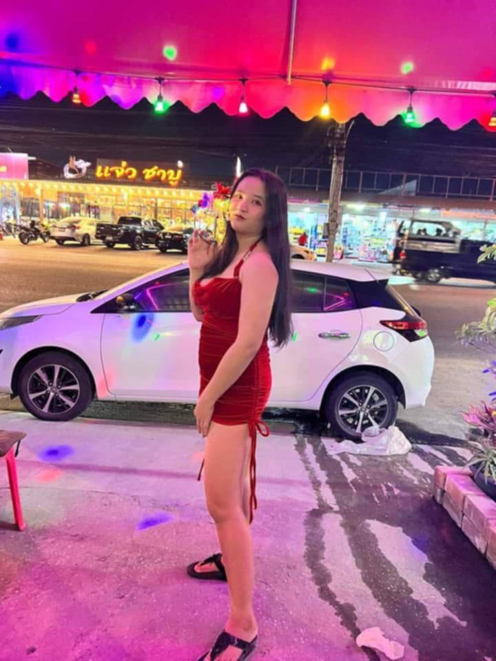 lady wearing short red dress with a white car in the background