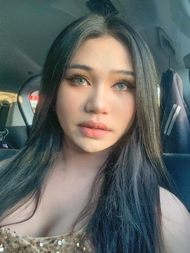 Facial shot of ladyboy therapist looking straight and wearing a gold sequence dress