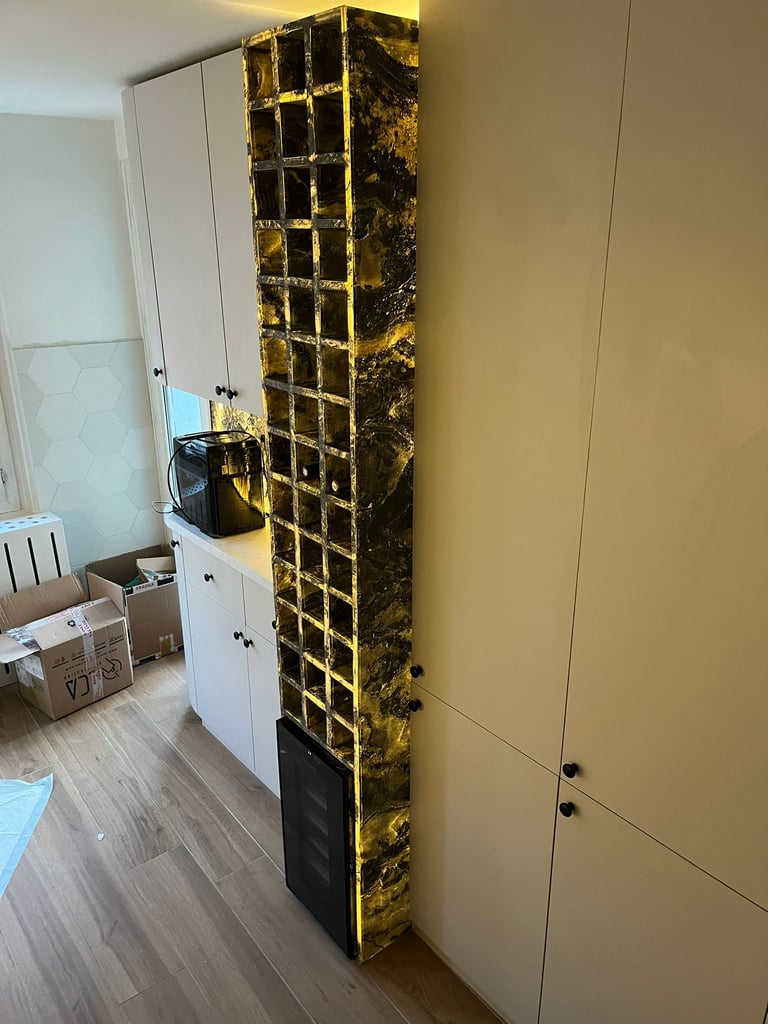 Custom backlit gold marble wine rack integrated into white modern kitchen cabinetry.