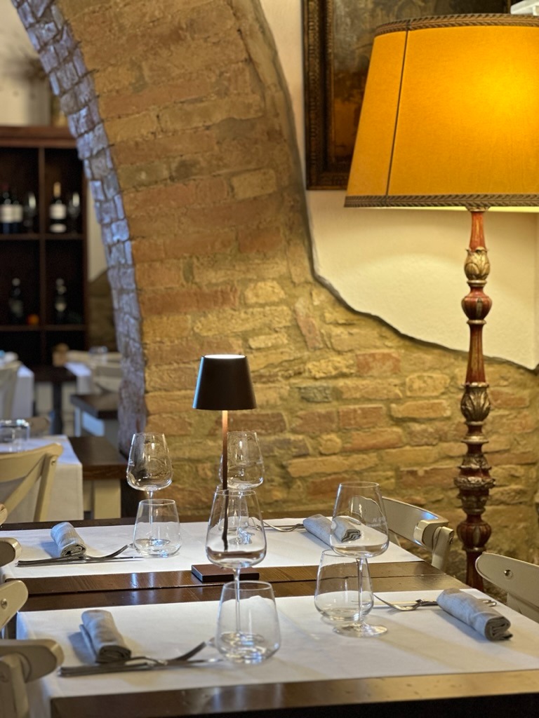 Sala interna del ristorante con mura in mattoni tipici toscani e tavolo apparecchiato - Rustic indoo