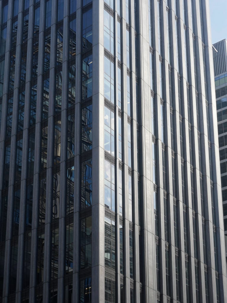 Cool corporate architecture of a financial district, glass and steel skyscraper facades reflecting crisp daylight, deep navy and silver tones, sharp focus, 35mm