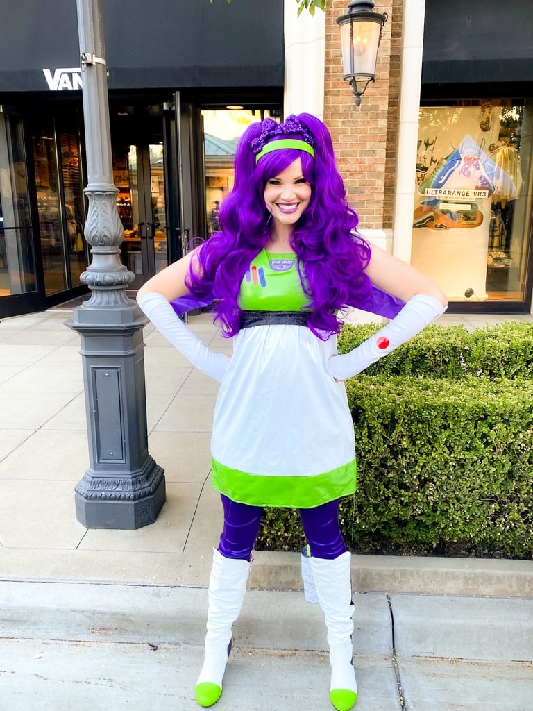 Woman  with a purple wig posing outside a store.