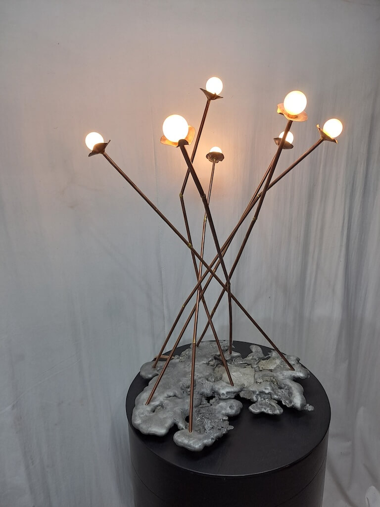 melted metal lamp base with metal poles to look like reeds as lights by Jan Vingerhoets