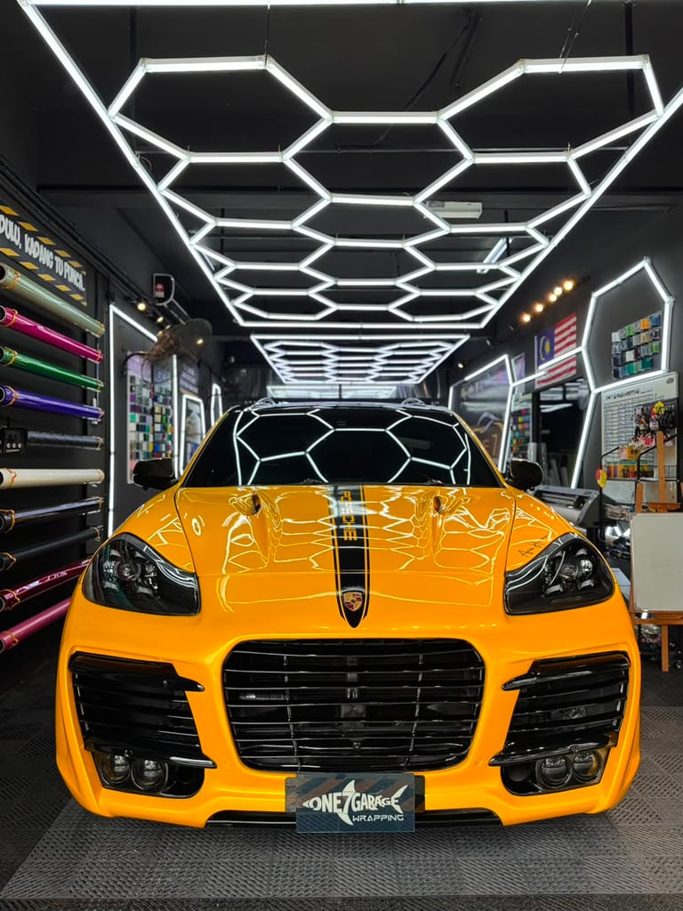 Porsche Cayenne wrapped in gloss yellow with black racing stripe