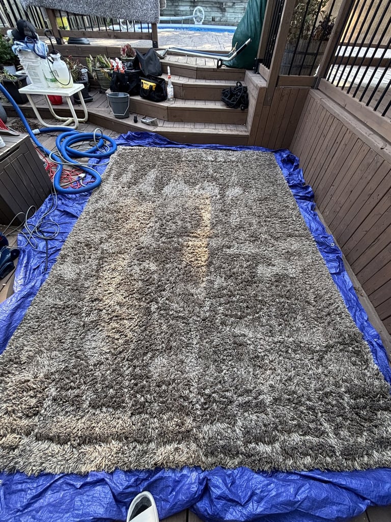 Gray rug on patio during deep cleaning. Outdoor rug cleaning for your convenience.