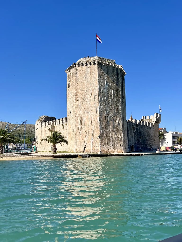Sea level view of Kamerlengo Fortress and UNESCO protected city of Trogir during a private boat tour from Split, Croatia