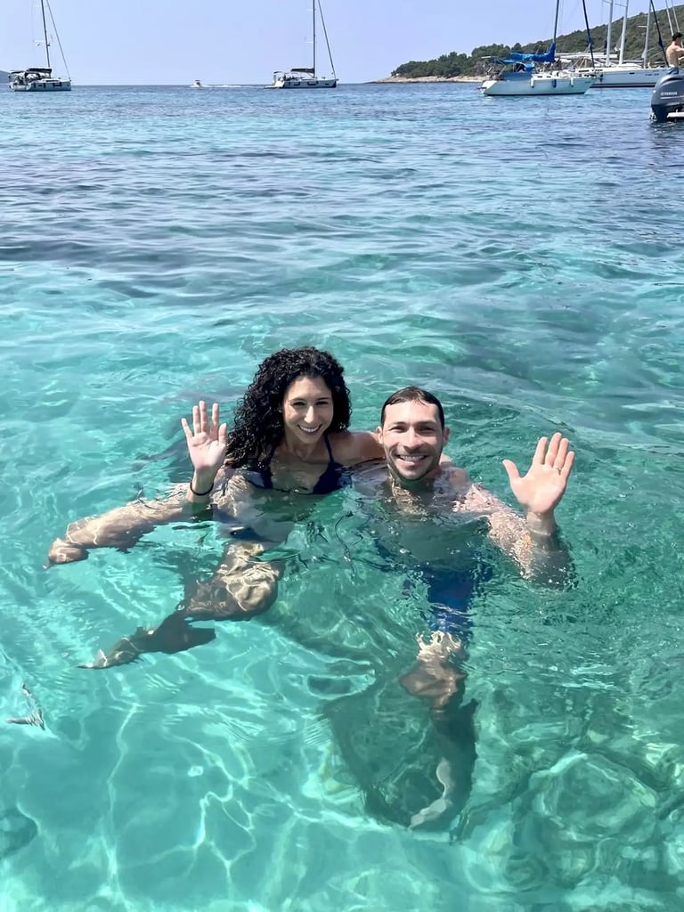 Couple swimming and waving in the turquoise waters of the Blue Lagoon during a boat trip from Split