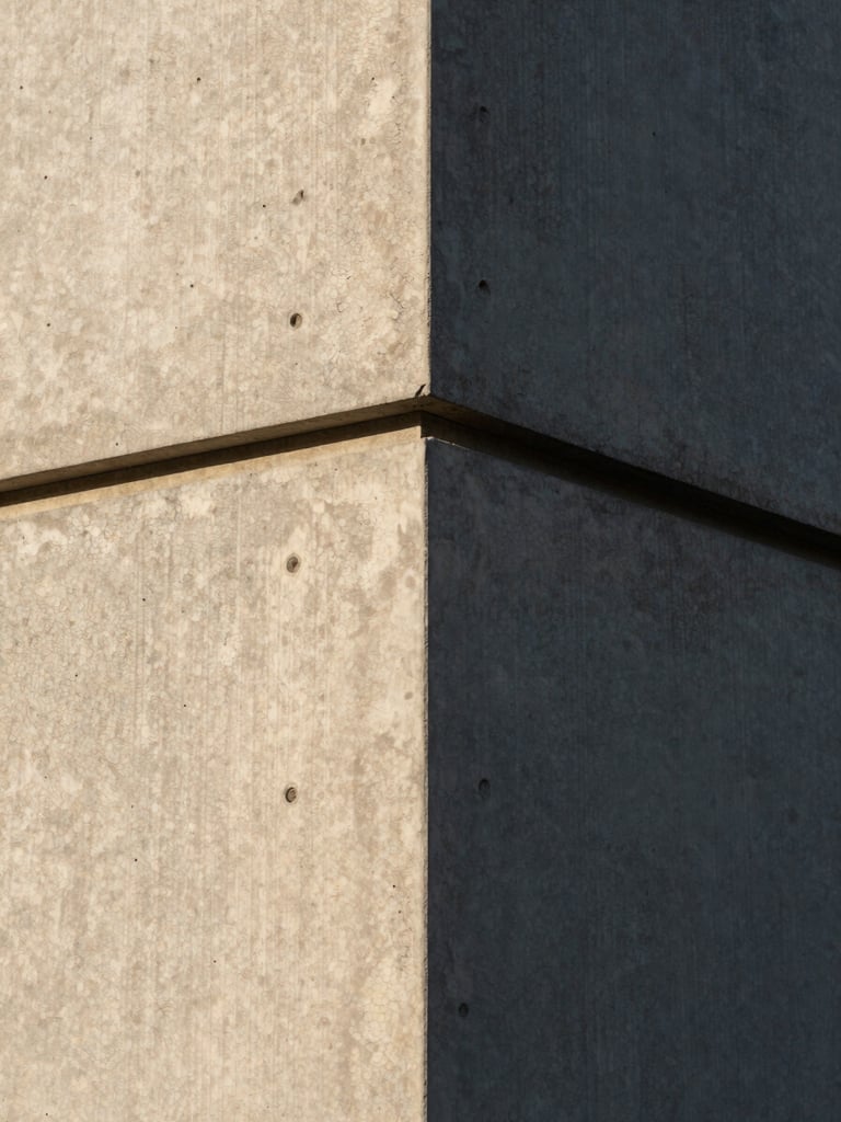 Extreme close-up of a crisp architectural concrete joint, sharp late afternoon shadows, rich material texture