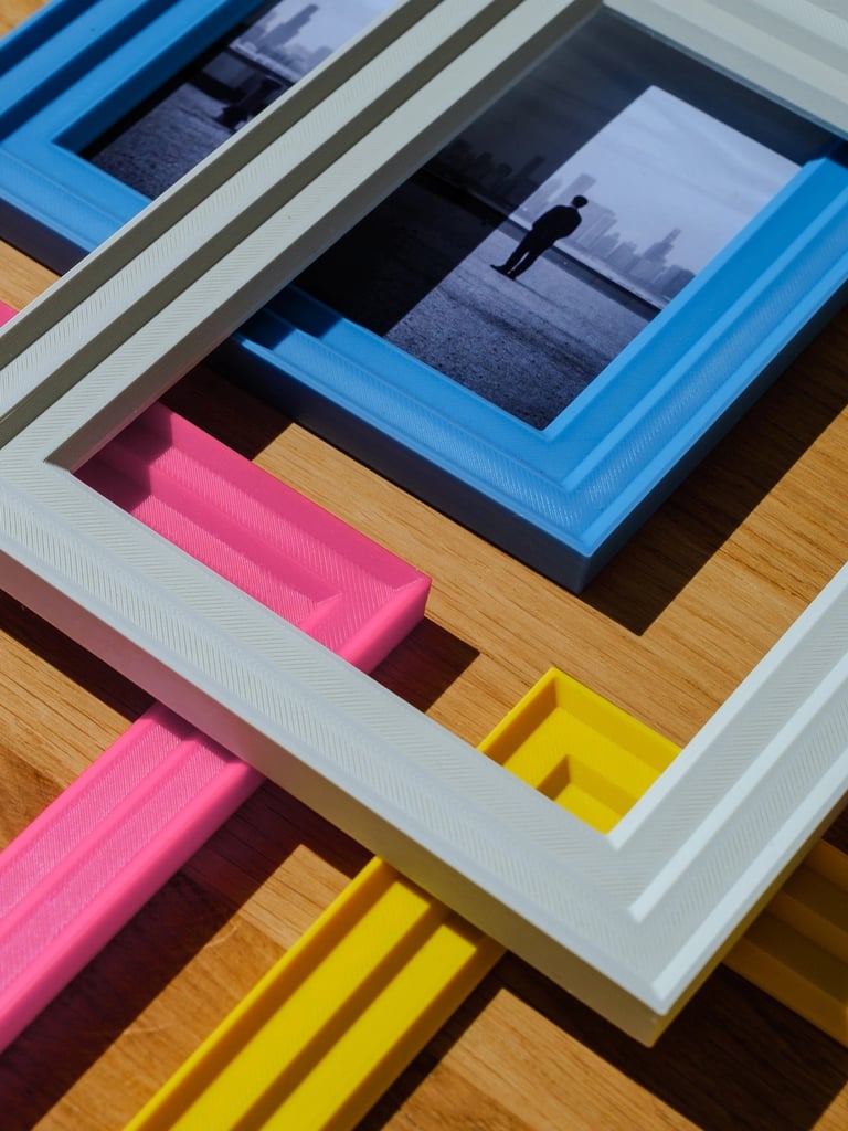     Customizable 3D printed colorful photo frames placed on a desk