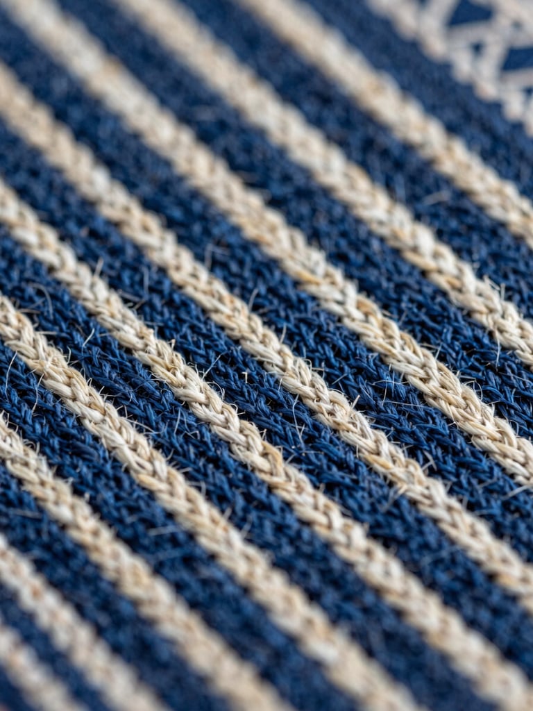 Extreme close-up macro of a hand-woven Indonesian textile surface, warp and weft threads in deep indigo and natural undyed cotton clearly distinct, north-facing natural daylight, no flash, sharp detail across the full frame