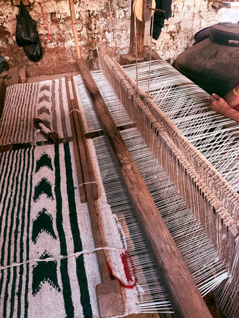 Textil artesanal con patrones geométricos siendo tejido en un telar tradicional de madera 