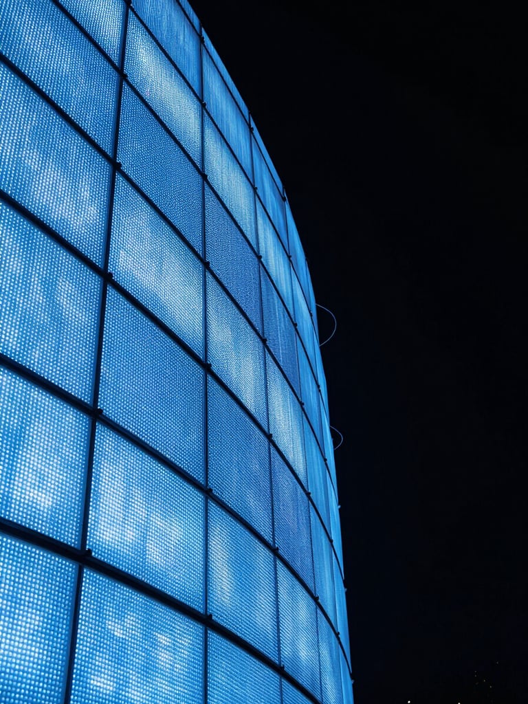 Extreme close-up portrait of a curved flexible LED panel installation at night, electric blue light tracing the arc of the curved screen surface, panel seams and bezels sharply detailed, deep black background, no people, technical precision in focus