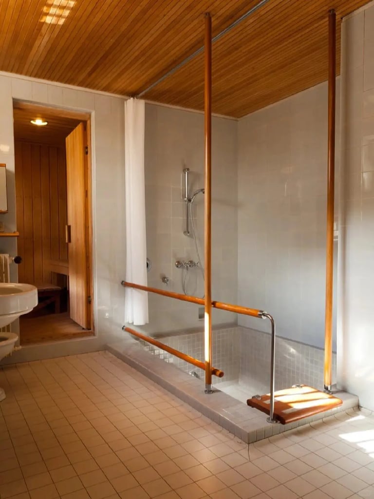 Warm bathroom interior with wood ceiling and natural details, reflecting Alvar Aalto’s use of honest