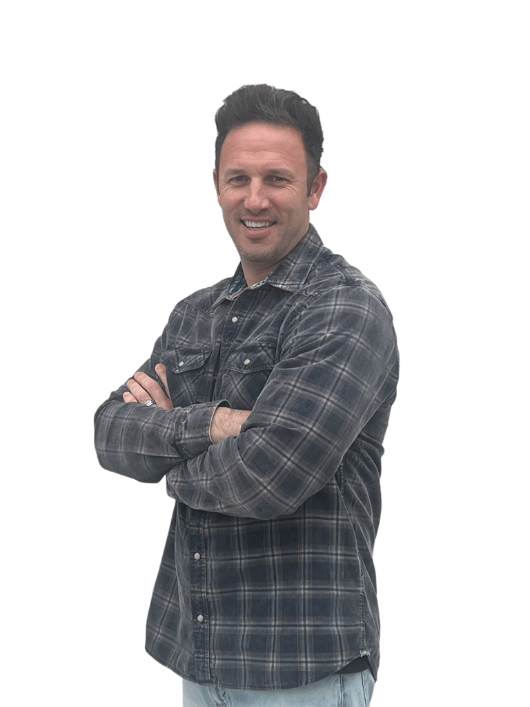 Smiling middle-aged man with short brown hair wearing a plaid button-down shirt posing with arms crossed.
