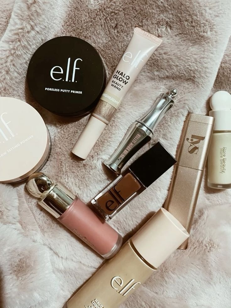 Productos de maquillaje de e.l.f., putty, Halo Glow y Rare Beauty sobre una alfombra.