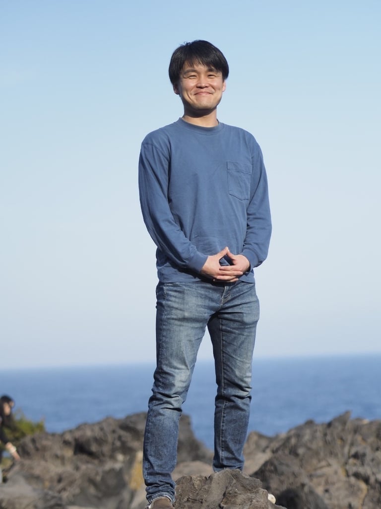 a man standing on a rock with his hands on his hips