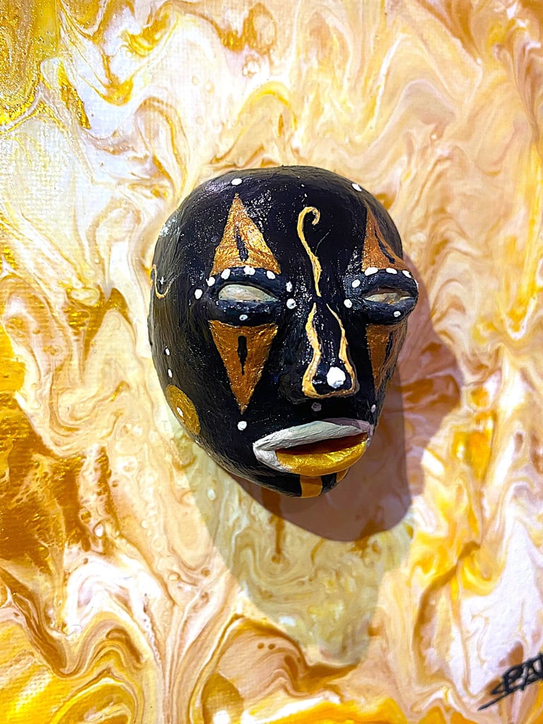 uns sculpture noir ressemblant à un masque qui émerge d'un tableau jaune vu de près